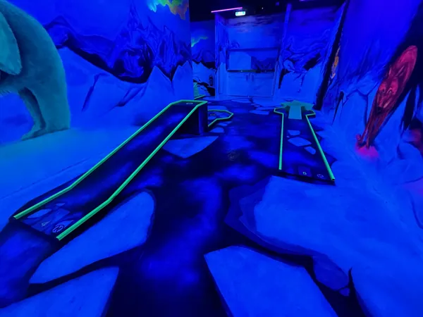 Minigolfbahn in der Eiswelt mit Eisbär und blau ausgeleuchteter Eislandschaft